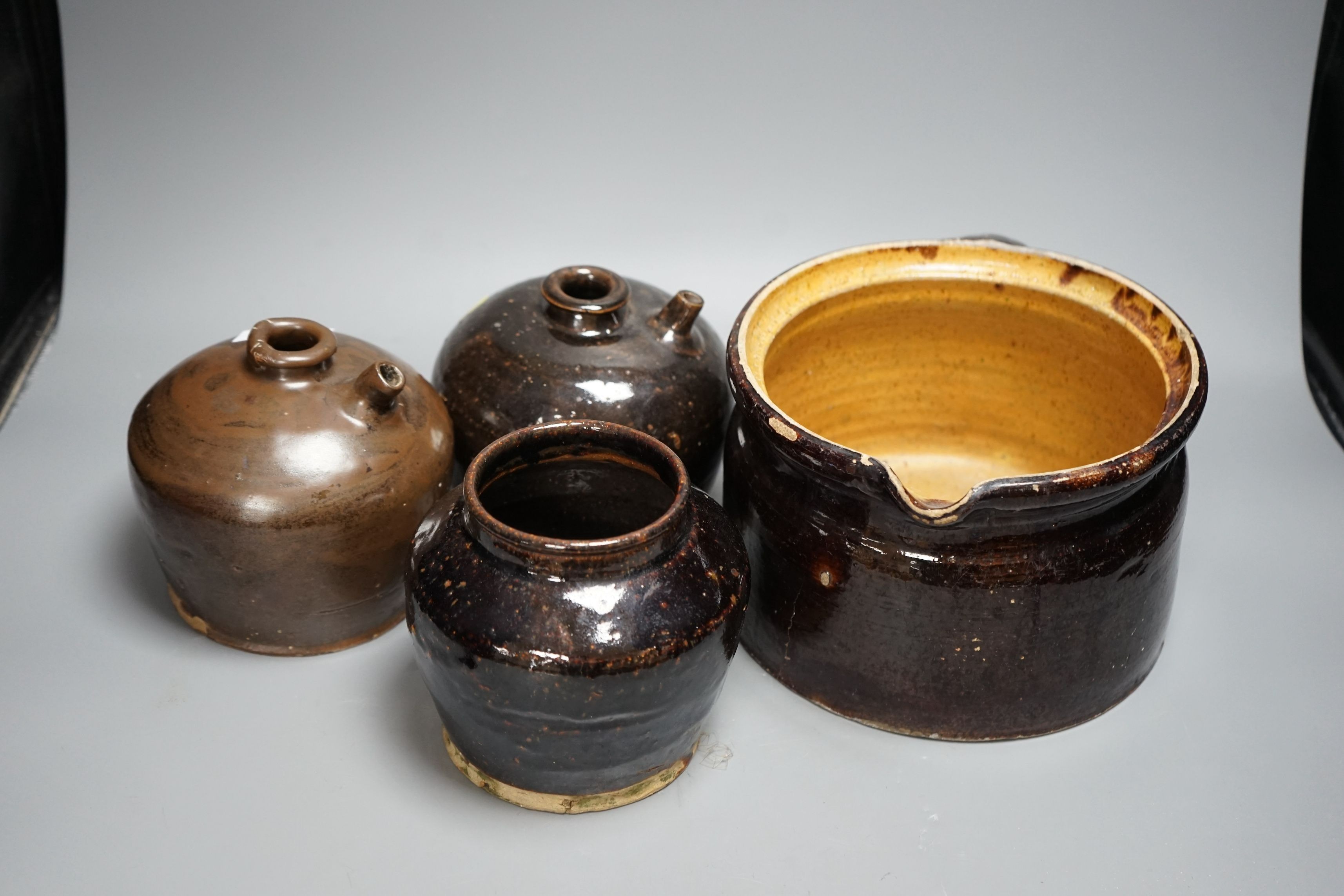 Two 19th century Chinese tenmoku glazed soy sauce jars, a similar jar and a pouring vessel, largest 14cm tall